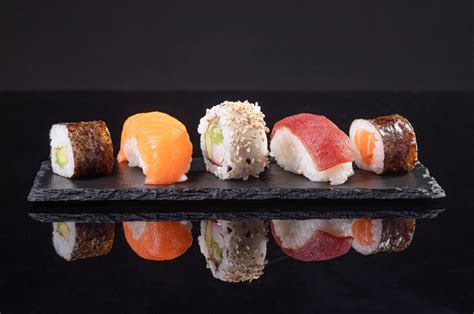 Plato de sushi variado, mostrando diferentes tipos de sushi con palillos y salsa de soja