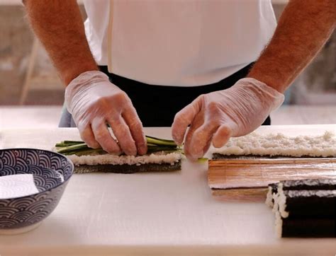 Foto de un chef de sushi (itamae) preparando nigiri con precisión detrás de una barra