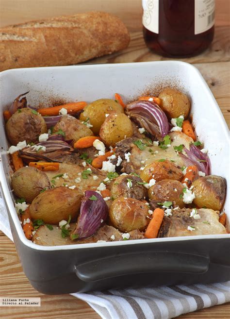 Fuente con chuletas de cerdo, queso feta y jugos de cocción listas para hornear