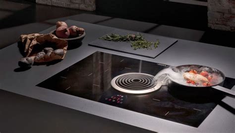 Esquema comparativo de una cocina equipada con parrilla de inducción y campana extractora de pared integrada.