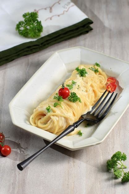 plato servido de cabello de ángel con vegetales y queso parmesano