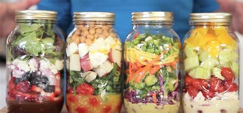 Imagen de varios frascos de vidrio con ensaladas en capas, mostrando la variedad de colores y texturas de los ingredientes.