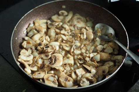 Foto del pollo y los champiñones salteándose en una sartén