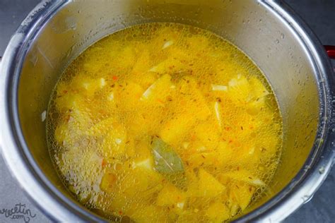 Patatas guisándose en una cacerola con la majada y el azafrán.