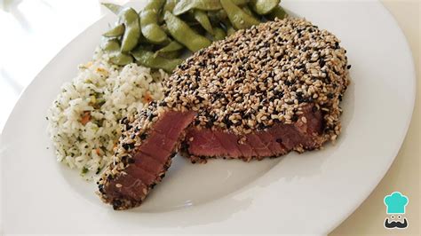 Foto de medallones de atún con costra de semillas en plato con guarnición