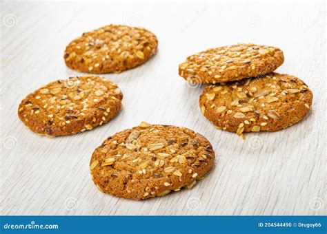 Fotografía profesional de galletas de avena con semillas de chía, rodajas de naranja fresca y un toque de miel sobre una superficie rústica