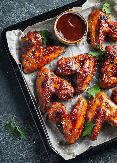 Alitas de pollo marinándose en una budinera con especias