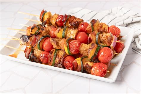 Detalle de ingredientes frescos para brochetas: carne, verduras y frutas