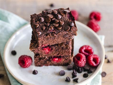 Fotografía cenital de un brownie vegano de harina de arroz recién cortado en porciones cuadradas con chispas de chocolate fundido por encima.