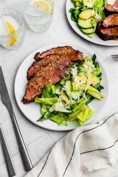 Fotografía de montaje final: Láminas de carne con mantequilla de ajo fundida y ensalada verde gourmet