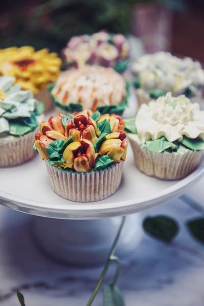 Mesa dulce con cupcakes decorados de diferentes colores y estilos