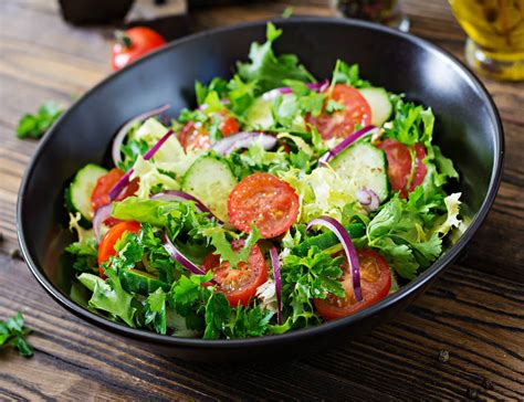 Plato de ensalada variada con una generosa porción de vinagreta de fresa.