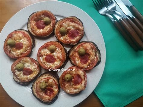 Montaditos de berenjena con hamburguesa, salsa de tomate y queso gratinado antes de servir.