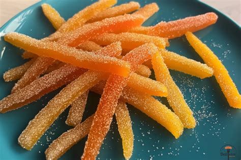 Rodajas de naranja confitada cortadas en trozos pequeños para añadir al dulce de membrillo.