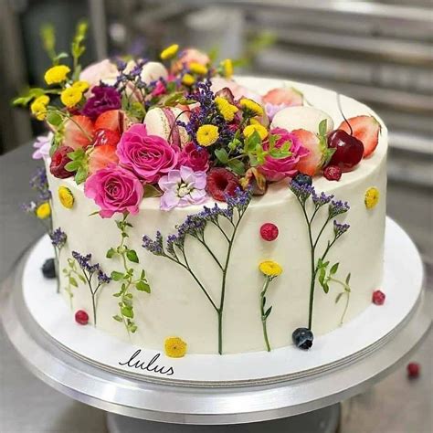 Pastel vegano de cumpleaños decorado con frutas y flores