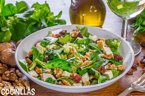 Ejemplo de ensalada emplatada con canónigos, pollo y frutos secos, aderezada con una vinagreta brillante de mostaza y miel.