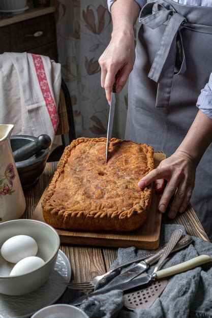 Foto de un pastel de pollo casero recién horneado, con la masa dorada y crujiente, servido en una mesa rústica.