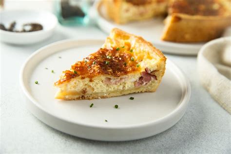 primer plano de una tarta de puerro y panceta dorada saliendo del horno en un molde desmontable