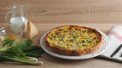 varias porciones de tarta de puerro servidas en una mesa de madera con una ensalada verde de acompañamiento