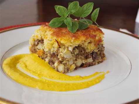 Plato de pastel de choclo recién horneado con una ramita de albahaca
