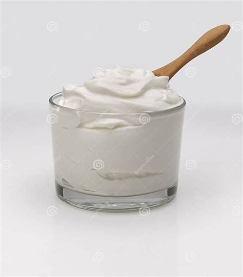 Yogur en un recipiente con cuchara sobre una mesa de madera