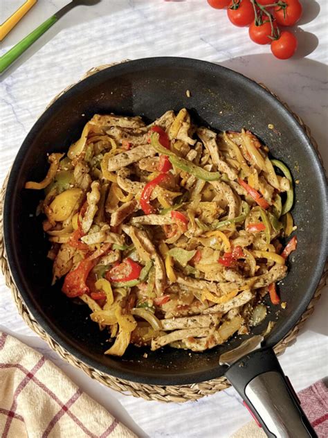 Plato servido de cerdo salteado con papas fritas y una porción de arroz