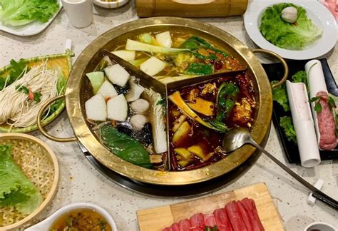 Fotografía de una olla caliente (hot pot) dividida con ingredientes vegetarianos frescos