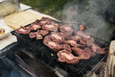 persona cocinando ostiones en una parrilla