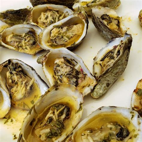 detalle de ostiones a la parrilla con mantequilla y hierbas