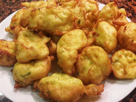 Buñuelos de bacalao recién fritos en un plato con papel absorbente