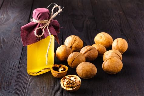 Foto de nueces enteras y aceite de nuez en una botella de vidrio