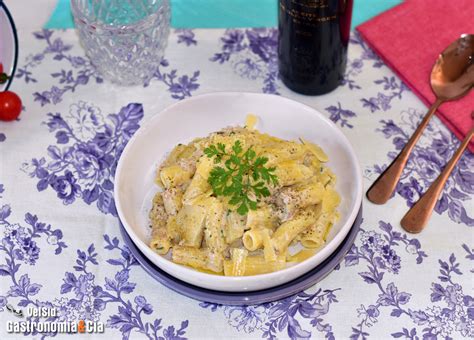 Plato de pasta con salsa cremosa de atún decorado con hierbas frescas