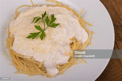 Fotografía profesional de pasta cubierta con salsa bechamel y queso rallado.