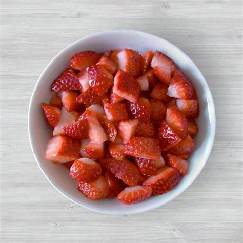 Fresas frescas cortadas en rodajas y trozos, listas para rellenar un pastel.