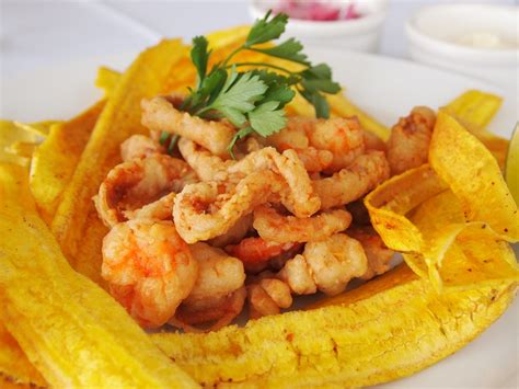 Plato de jalea de mariscos servido con cebolla encurtida y rodajas de limón