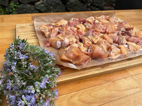 Esquema de un pollo troceado o entero listo para cocinar en sartén con sus condimentos principales alrededor