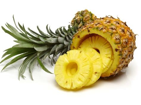 Fotografía profesional de una piña natural partida por la mitad y rellena con una bola de helado, decorada con frutos rojos y menta.