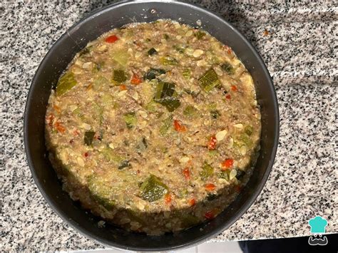 Ingredientes frescos para budín de zapallo italiano con carne molida dispuestos en una tabla de cocina