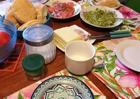 Imagen de una mesa servida con una once chilena, incluyendo té, pan y un queque artesanal recién horneado