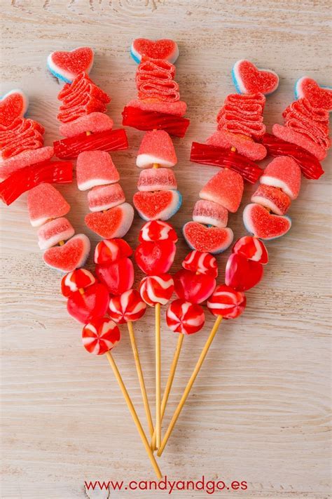Ejemplo de brochetas de golosinas y conos decorados en tonos rosa y blanco.