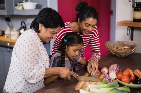 Niños ayudando a preparar la comida en la cocina, con ingredientes frescos y coloridos.