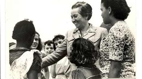 Fotografía de Gabriela Mistral con niños o en un entorno escolar, evocando su maternidad espiritual