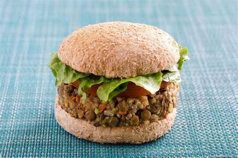 Imagen de hamburguesas de lentejas doradas acompañadas de aguacate y pan integral