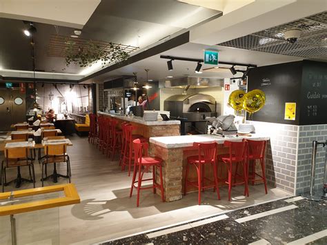 Fachada de la Pizzería Starita en Turín con clientes esperando, estilo tradicional