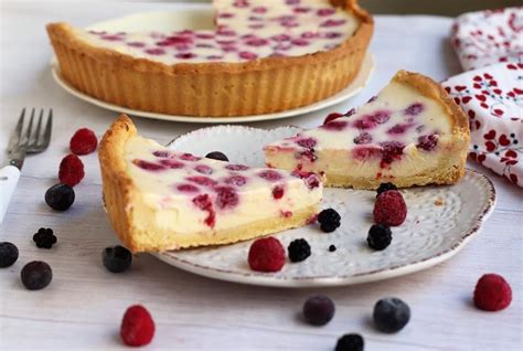 Fotografía profesional de un kuchen de ricota y yogurt con frutos rojos sobre una mesa de madera