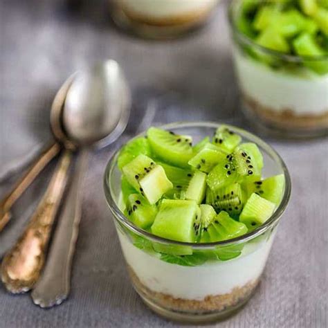 Primer plano de vasitos de cheesecake de kiwi con capas visibles