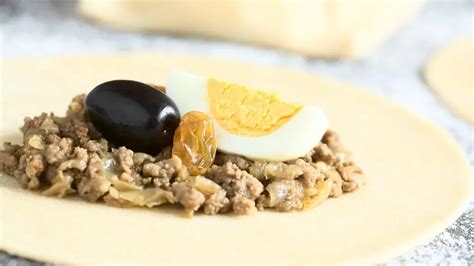 Fotografía de los ingredientes del pino: carne picada, cebolla, huevo duro, aceitunas y pasas