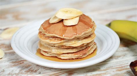 Mesa con ingredientes para panqueques veganos de cacao: harina, cacao, banana, sirope de maple, semillas de chía, leche vegetal.