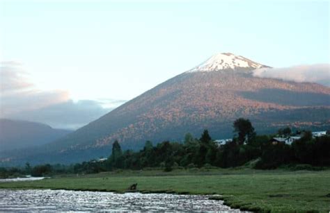 Foto panorámica de Hornopirén con el volcán de fondo, mostrando cabañas y hostales.