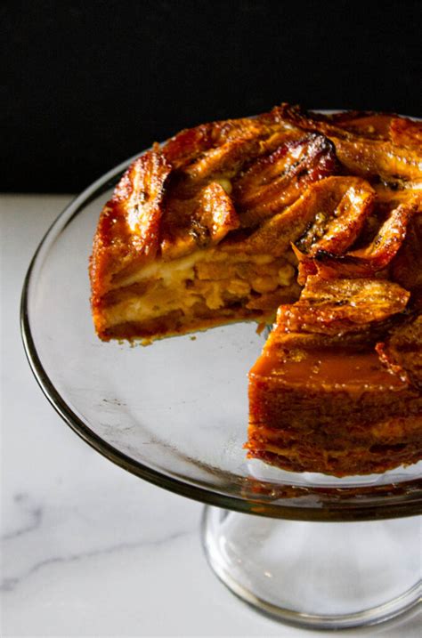 Fotografía de primer plano de una porción de torta de plátano servida en un plato, mostrando su textura suave y dorada.